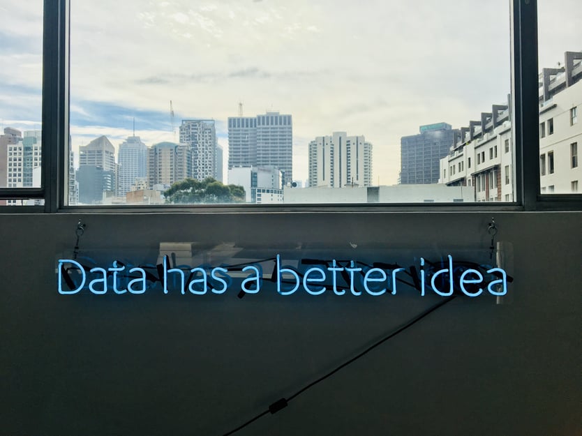 Udsigt til højhuse og væg med tekst i neonlys: "Data has a better idea"